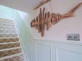 A staircase with a wooden wall decoration at Mayflower Cottage in Lyme Regis