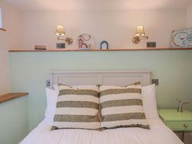 A bedroom with a bed and decorative items at Mayflower Cottage in Lyme Regis