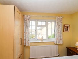 A bedroom with a wardrobe, window, and nightstand at Number 10, Broadway