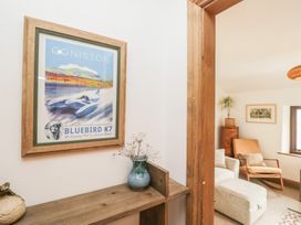 A living room with a framed poster and wooden shelf at Over Brow Cottage in Coniston