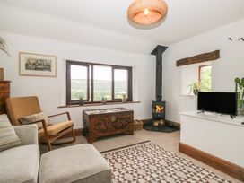 A living room with a fireplace and a television at Over Brow Cottage in Coniston