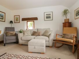 A living room with a sofa and armchair at Over Brow Cottage in Coniston