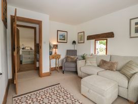 A living room with a sofa and armchair at Over Brow Cottage in Coniston