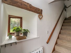 A hallway with a window and potted plants at Over Brow Cottage in Coniston
