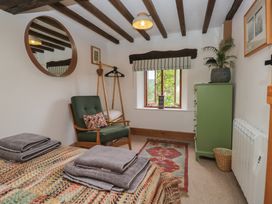 A bedroom with a bed and chair at Over Brow Cottage in Coniston