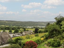A view of fields and houses with a lake at Over Brow Cottage in Coniston