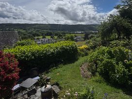 A garden with chairs and a table at Over Brow Cottage in Coniston