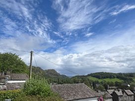A view of rooftops and hills under a cloudy sky at Over Brow Cottage in Coniston