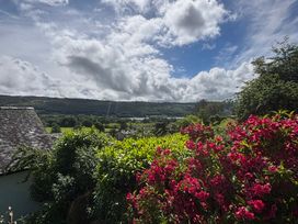 A view featuring flowers and trees with mountains in the background at Over Brow Cottage, Coniston