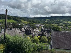 A view of houses and trees with mountains in the background at Over Brow Cottage in Coniston