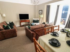 A living room with a television and dining area at Sea Suite