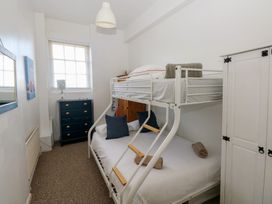A bedroom with a bunk bed and dresser in Sea Suite