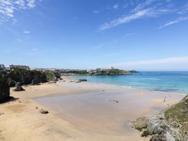 A beach with people and cliffs at Two Bed Apartment No.4 Newquay