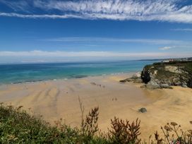 A beach with people and a cliff at Two Bed Apartment No.4 in Newquay