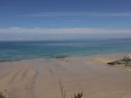 A beach with people walking on sand and water in Penthouse No.3 Newquay