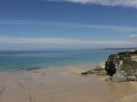 A beach with people and a cliff at Penthouse No.3 in Newquay