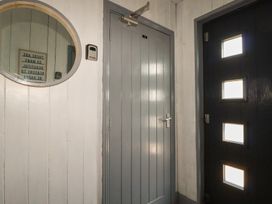 A hallway with a round mirror and two doors at Penthouse No.3 in Newquay