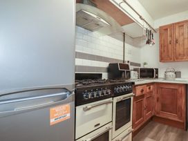 A kitchen with a gas stove, fridge, and countertop at Penthouse No.3 in Newquay