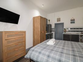 A bedroom with a bed and television at Penthouse No.3 in Newquay