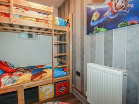 A bedroom with a bunk bed and wall art at Penthouse No.3 in Newquay