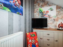 A bedroom with a television and Mario chair at Penthouse No.3 in Newquay