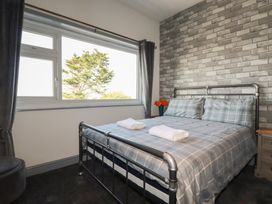 A bedroom with a bed and window at Penthouse No.3 in Newquay