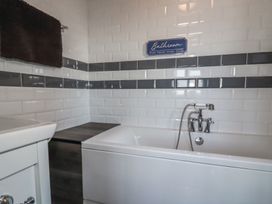 A bathroom featuring a bathtub and a wall sign at Penthouse No.3 in Newquay
