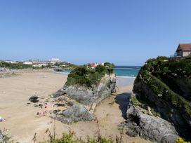 A beach with rock formations and buildings at Penthouse No.3 in Newquay
