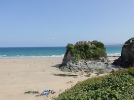 A beach with a rock formation and people enjoying the sun at Penthouse No.3 in Newquay