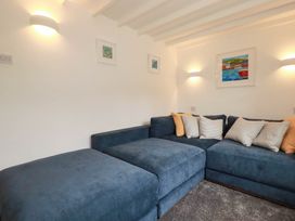 A living room with a sofa and wall art at Little House in Wadebridge