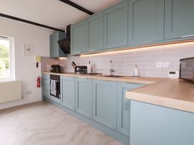 A kitchen with cabinets, sink, and appliances at Little House in Wadebridge