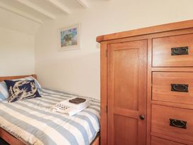 A bedroom with a bed and storage furniture at Little House in Wadebridge