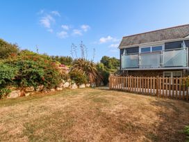 A garden with a fence and house with a balcony at Little House in Wadebridge
