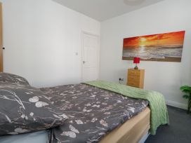 A bedroom with a bed and lamp at Ocean Breeze in Weymouth