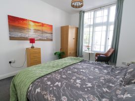 A bedroom with a bed and wardrobe at Ocean Breeze in Weymouth