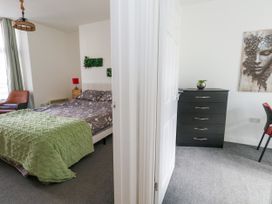A bedroom with a bed and a dresser at Ocean Breeze in Weymouth