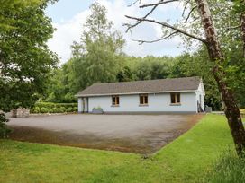A house with a parking area and trees at a 3 bed property
