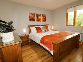 A bedroom with a bed and nightstand at 3 bed property