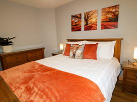 A bedroom with a bed and nightstands at 3 bed property