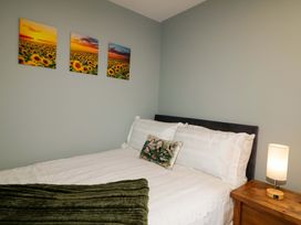 A bedroom with a bed and wall art at 3 bed property