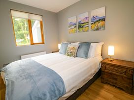 A bedroom with a bed and artwork on the wall at 3 bed property 