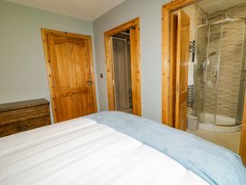 A bedroom with a bed and attached shower at a 3 bed property