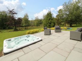 A garden with a hot tub and outdoor seating at 3 bed property
