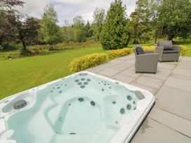 An outdoor area with a hot tub and chairs in a garden