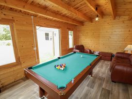 A game room with a pool table and sofas at 3 bed property