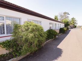 A pathway alongside a building with bushes at Cottage 1 Tenby