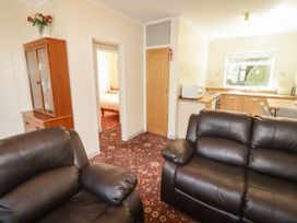A living room with a sofa and cabinets at Cottage 1 in Tenby