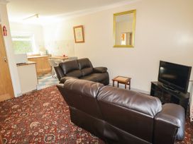 A living room with a couch and tv at Cottage 1 Tenby