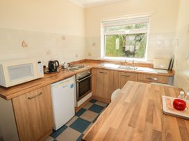 A kitchen with appliances and a sink at Cottage 1 in Tenby