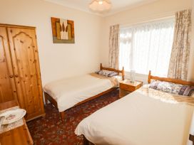 A bedroom with two beds and a wardrobe at Cottage 1 in Tenby